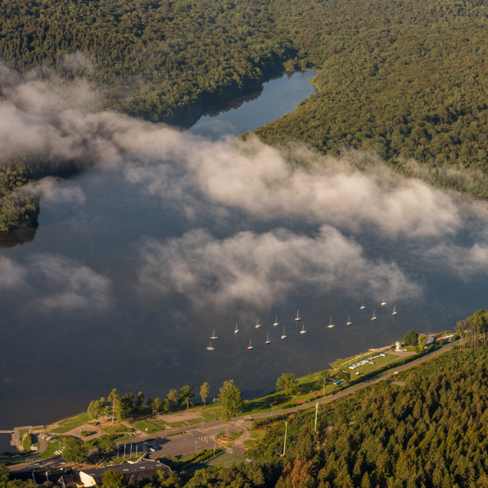 Lac des vieilles forges au sein du Parc naturel régional des Ardennes avec reflets de nuages et forêts